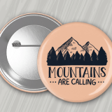 Peach colored 2.25" round button with pin back featuring the phrase 'Mountains are calling- 2.25 Custom Round Buttons